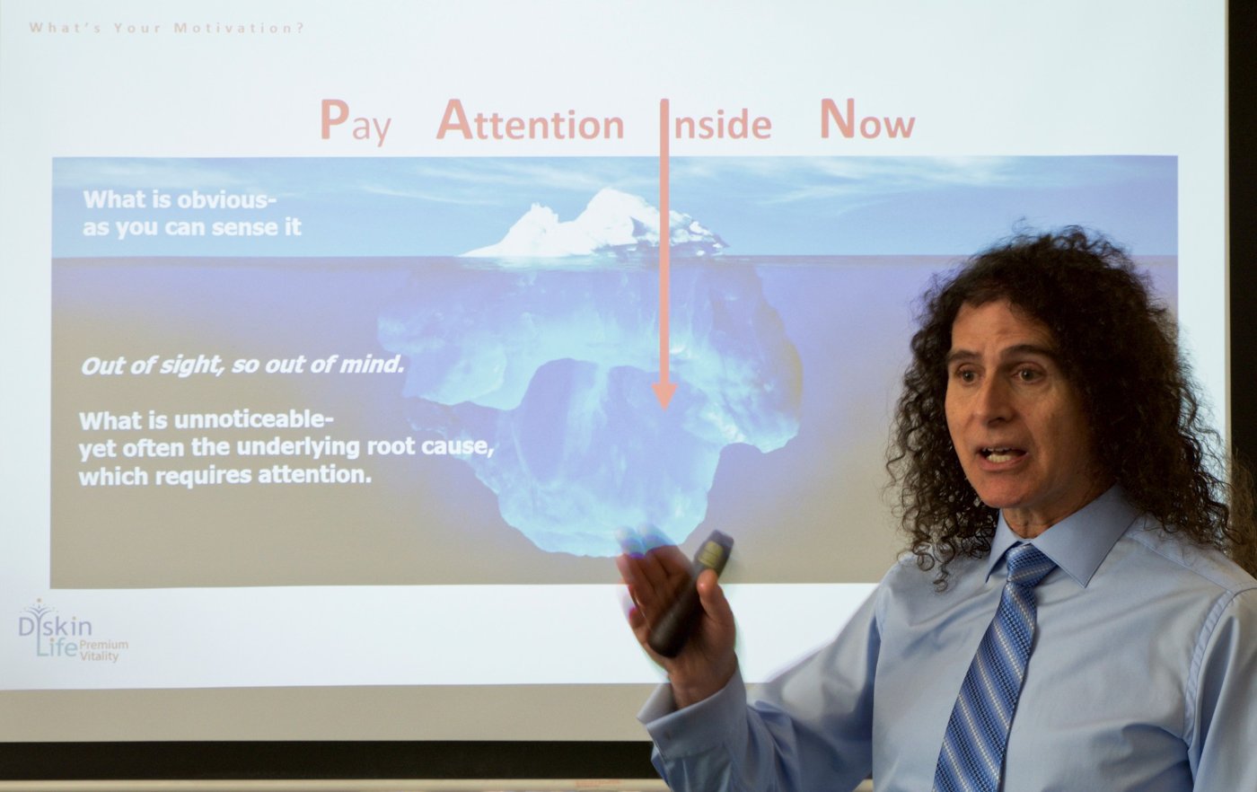 Dr Ari Diskin presenting a slide titled Pay Attention Inside Now, with an iceberg showing what lies below the surface
