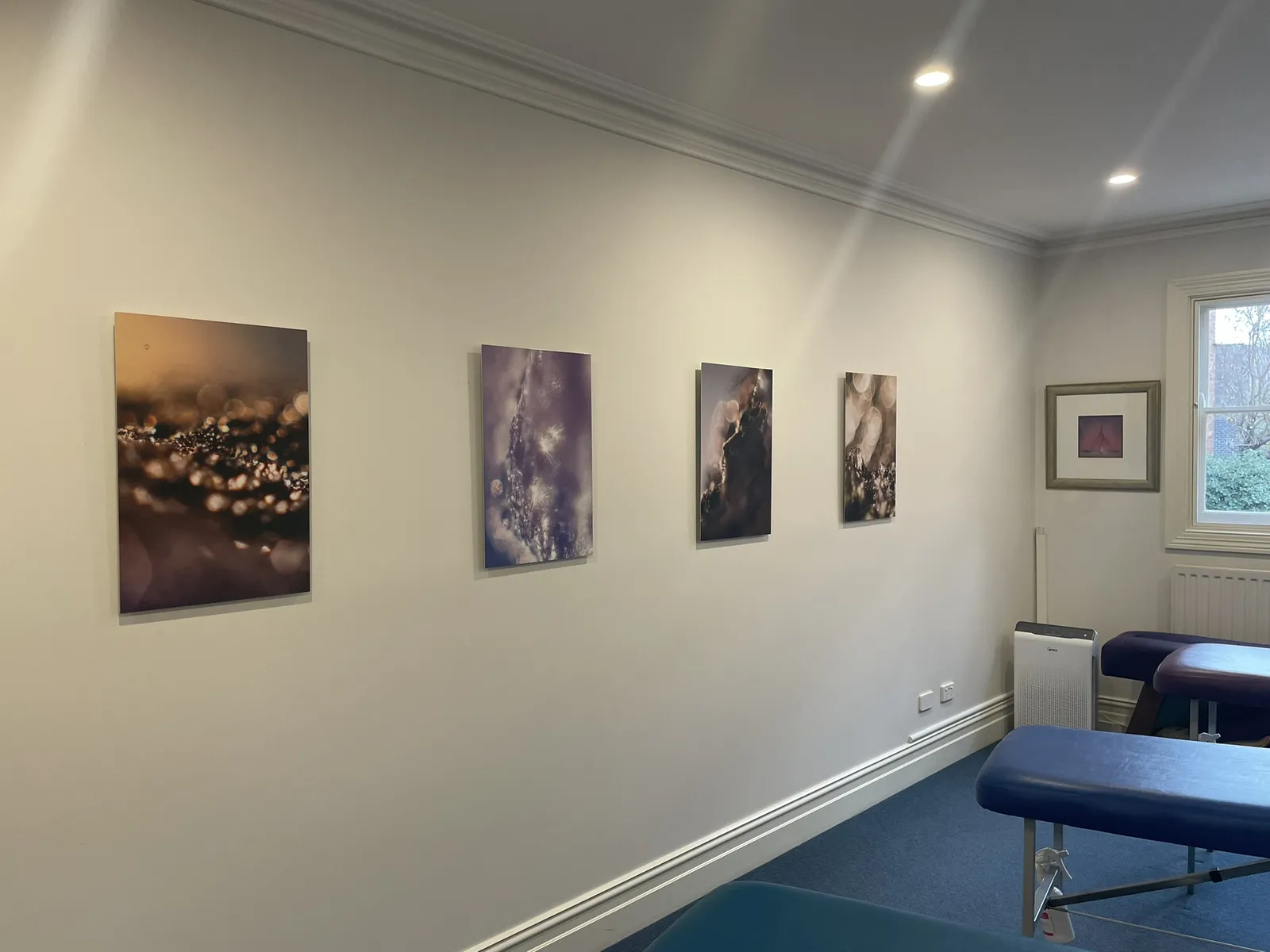 A row of Keys to Awaken Resonance Art canvases above a bench in the adjusting zone at Diskin Life Fitzroy