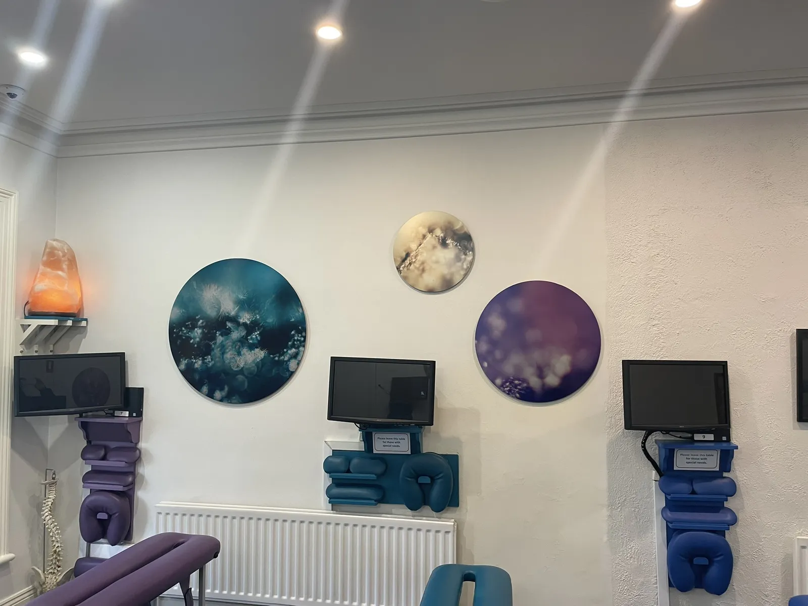 The adjusting zone at the Diskin Life Centre in Fitzroy, three round Keys to Awaken works on the wall above the tables, with a salt lamp and the scanning screens