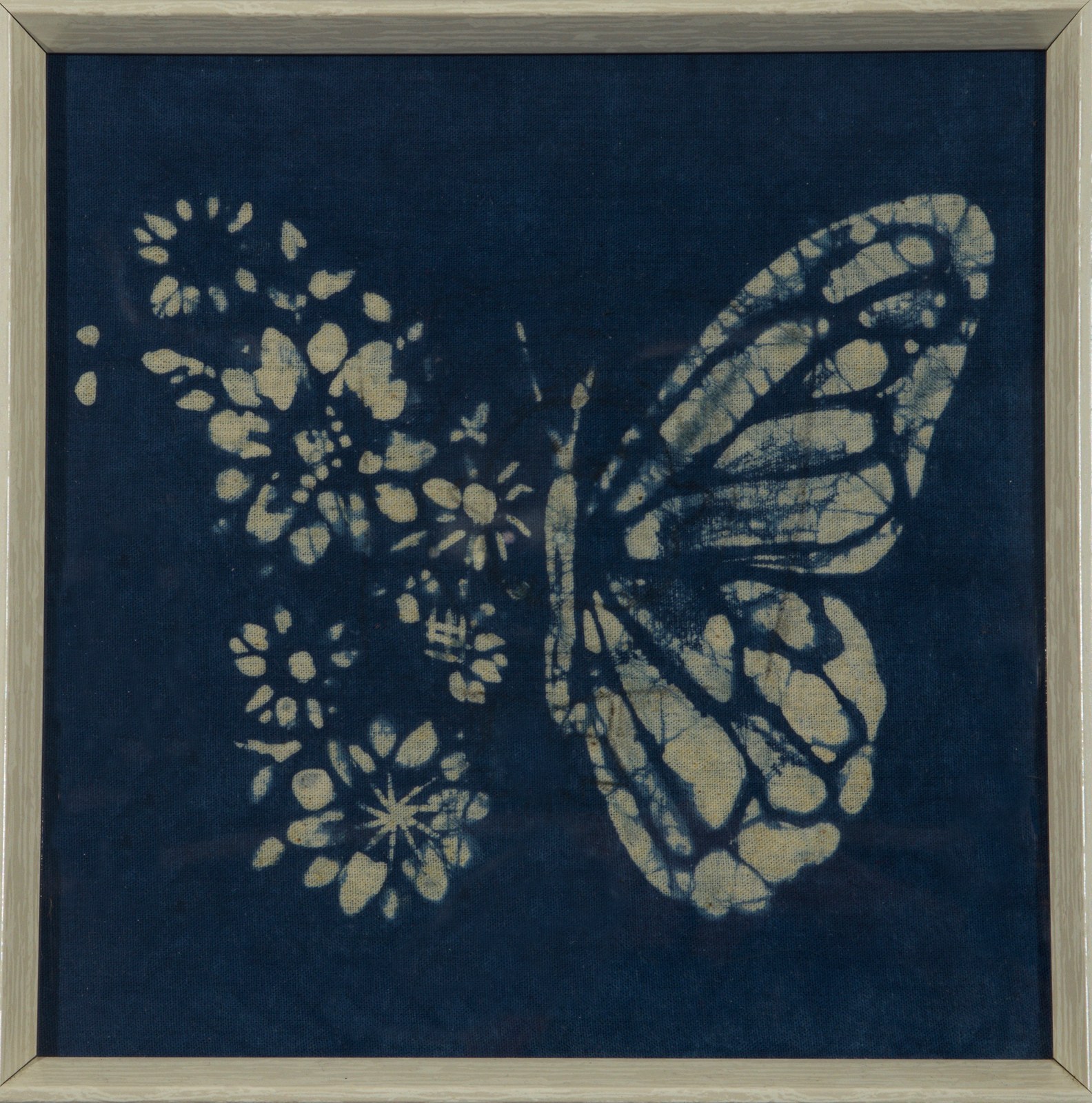A cyanotype butterfly formed from pressed blossoms, framed on a wall at the Diskin Life Centre