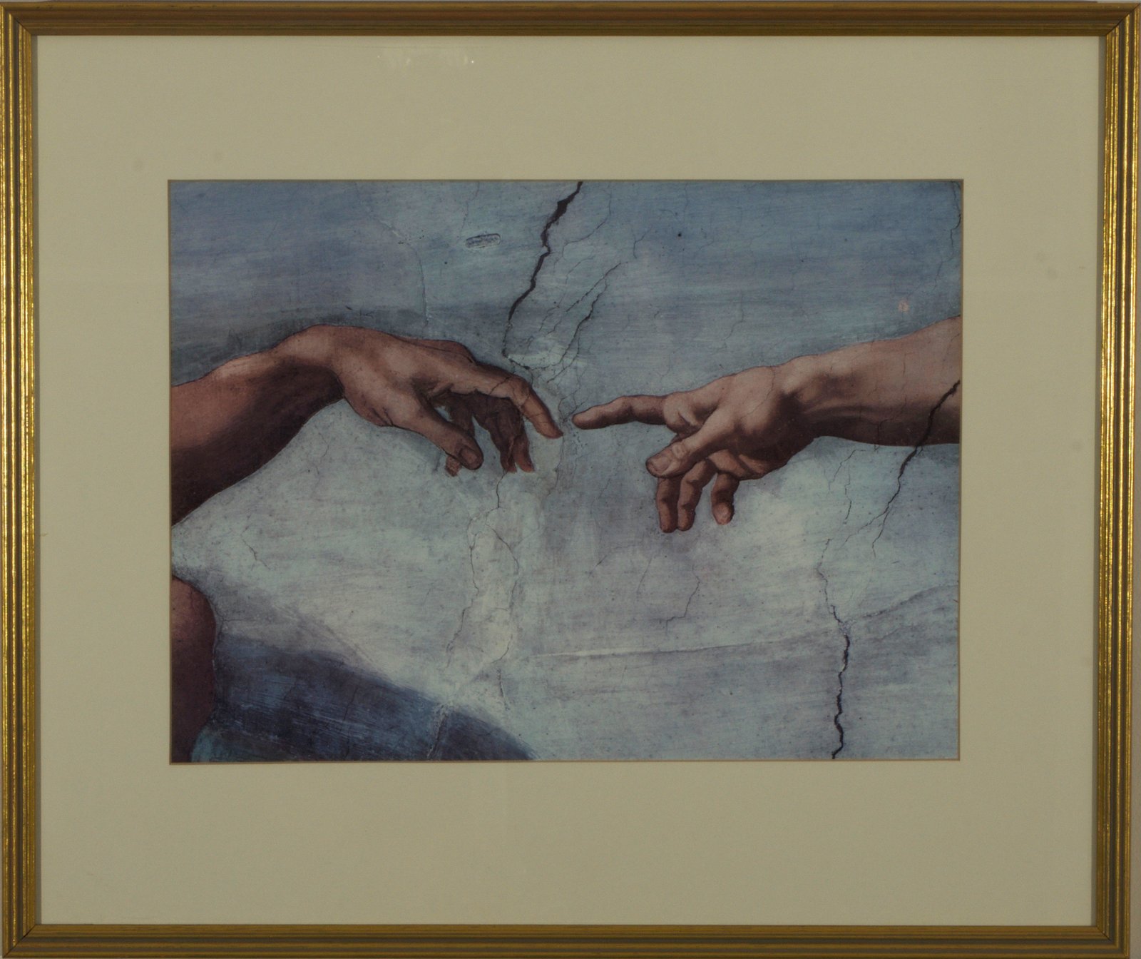 A framed reproduction of the Creation of Adam on the wall at Diskin Life: two hands reaching towards each other, fingertips almost touching.