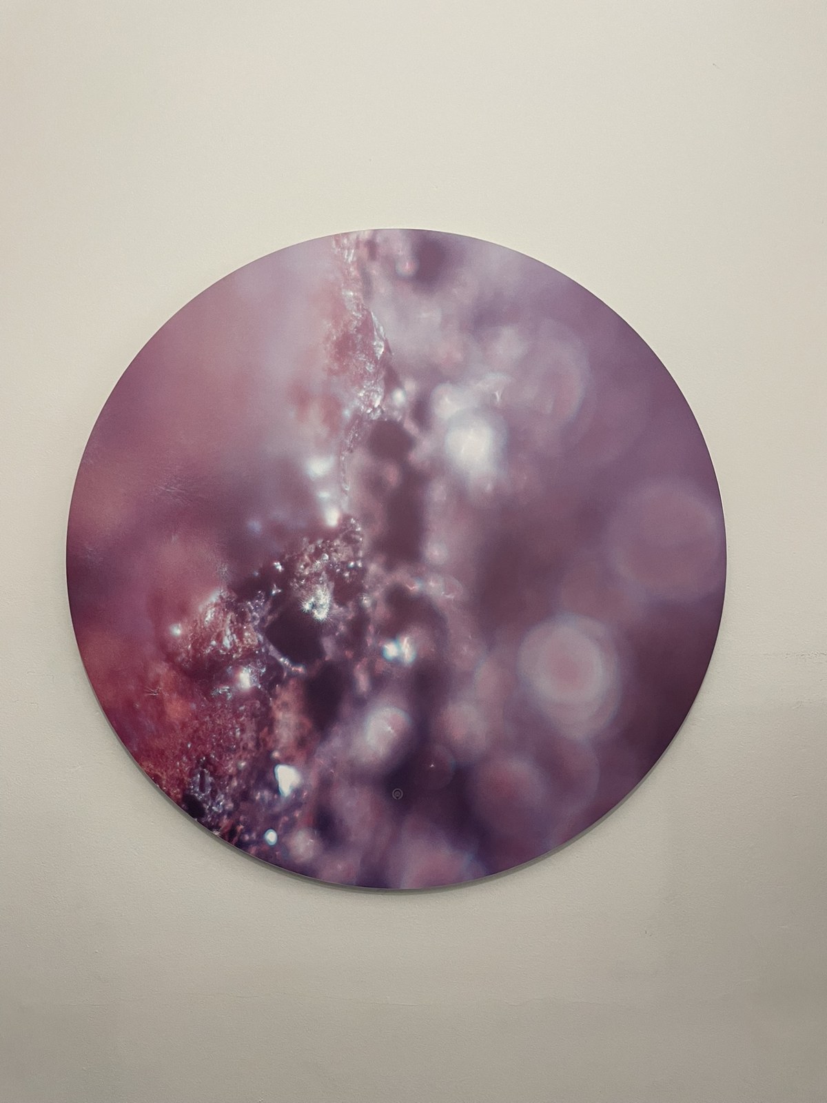 A circular Keys to Awaken Resonance Art work in rose and violet, flecked with points of light