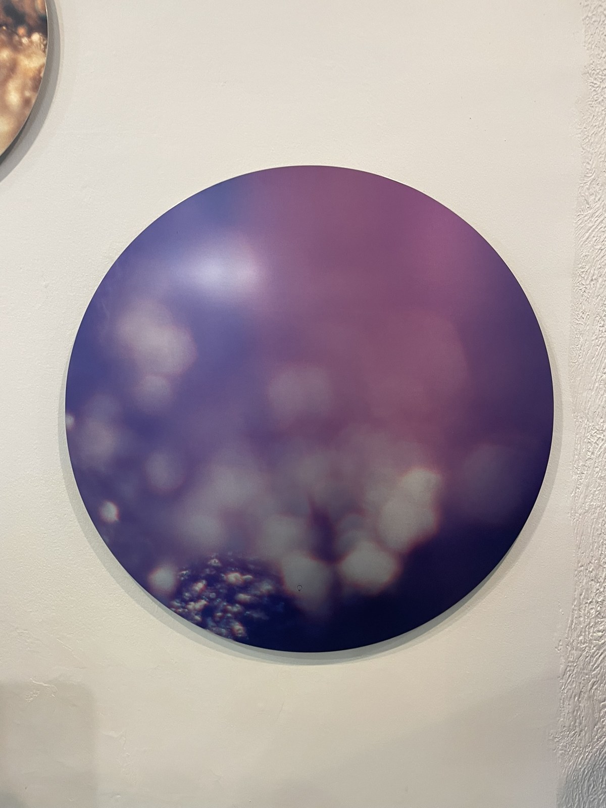 A circular Keys to Awaken Resonance Art work in violet and blue, softly lit from within