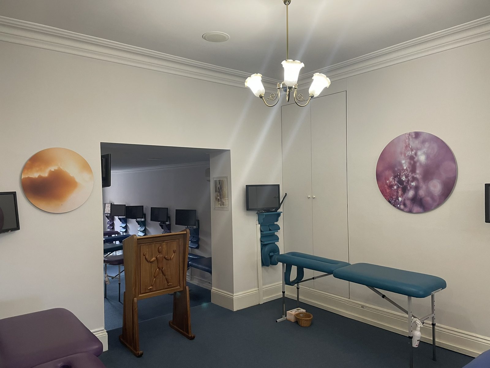 A circular amber Keys to Awaken work beside the doorway of the adjusting zone, the next room visible beyond