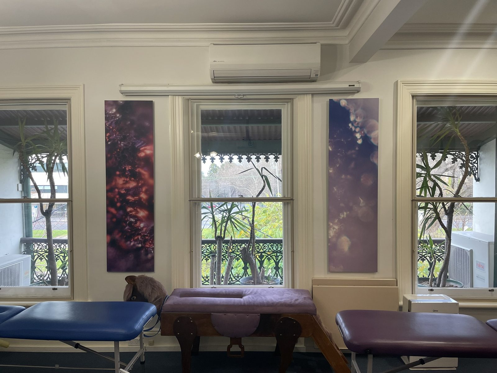 Two tall Keys to Awaken works hung between the sunlit windows of the adjusting zone