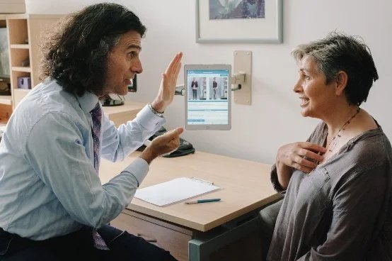 Dr Ari Diskin in consultation with a client at the Diskin Life Centre in Fitzroy, talking through what he is looking at